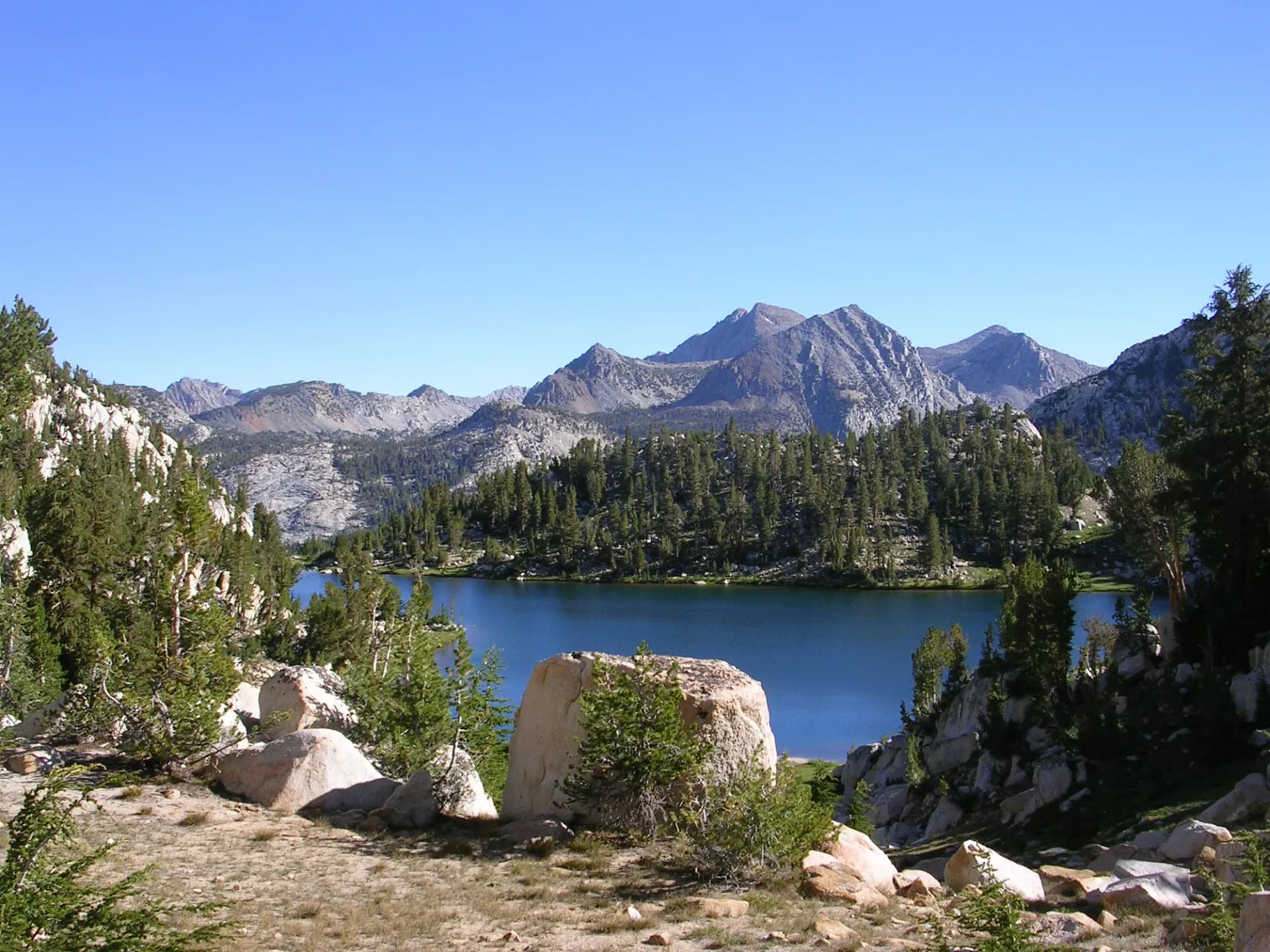 Lake of the Lone Indian high-altitude alpine lake surrounded by granite peaks and sparse conifers, John Muir Wilderness, Sierra National Forest, California
